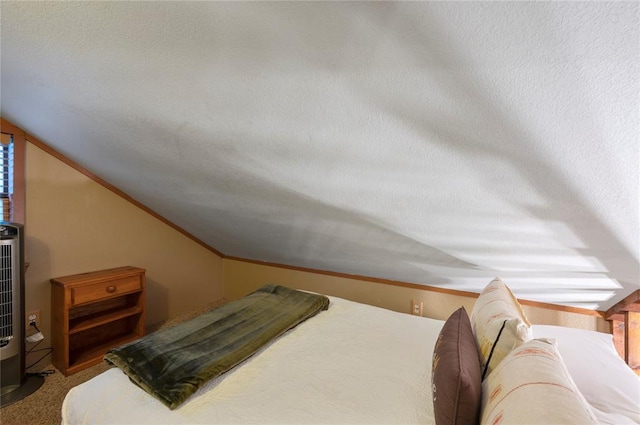 bedroom with ornamental molding, lofted ceiling, a textured ceiling, and carpet