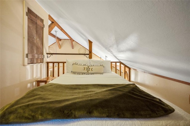 bedroom featuring vaulted ceiling and a textured ceiling