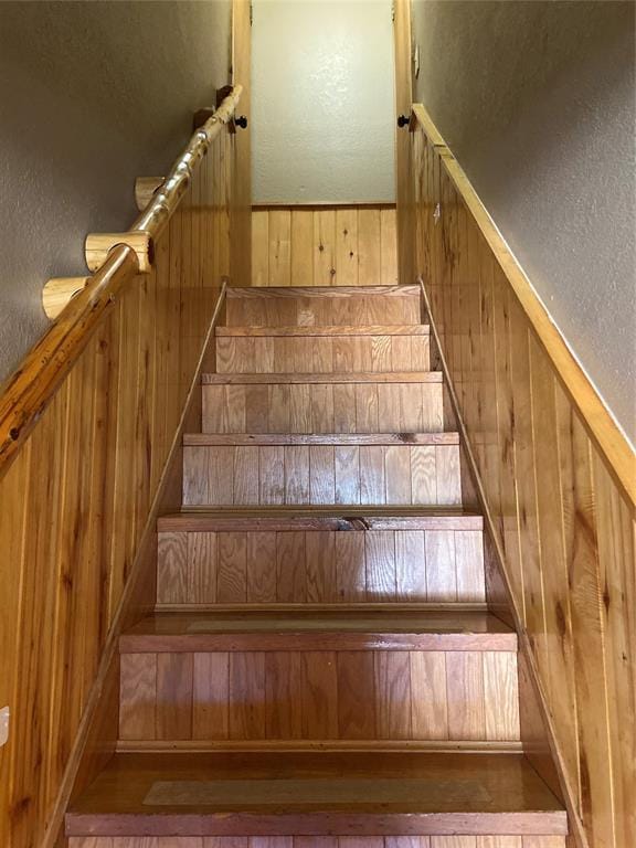 stairway with a textured wall and wood walls