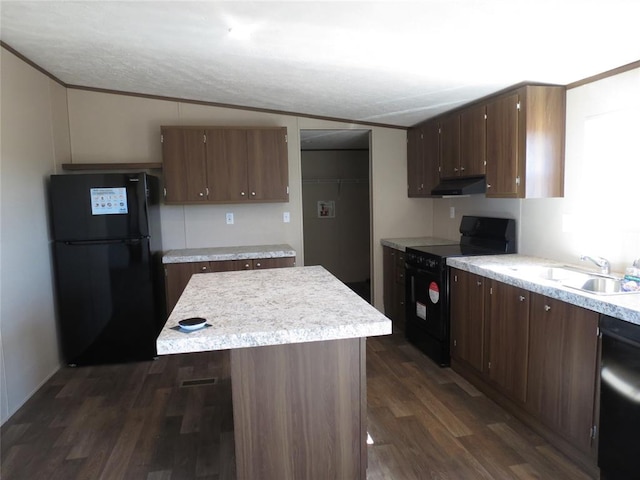 kitchen featuring dark wood-style flooring, light countertops, a sink, under cabinet range hood, and black appliances