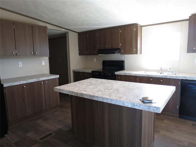 kitchen featuring black appliances, under cabinet range hood, light countertops, and a sink