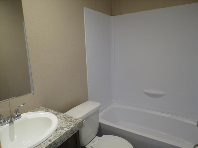 bathroom with tub / shower combination, vanity, and toilet