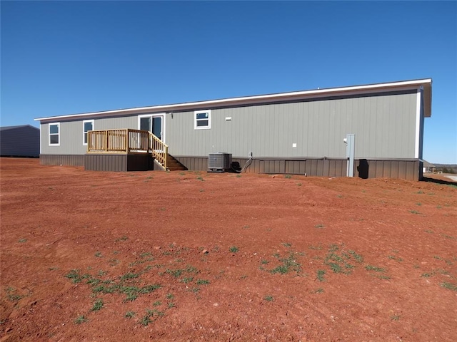 back of house with a wooden deck and central AC unit