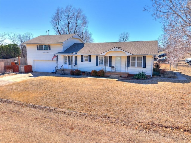 tri-level home with driveway, an attached garage, and fence