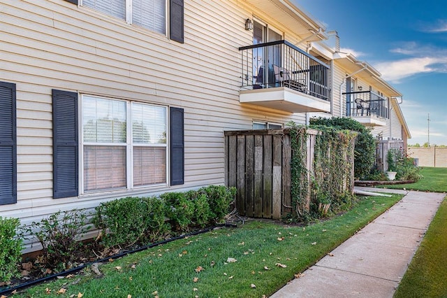 view of property exterior featuring a lawn and a balcony