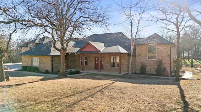 view of front of house featuring a patio and brick siding