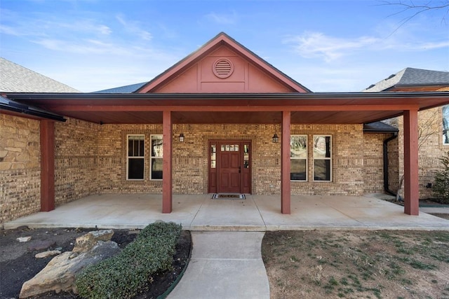 entrance to property featuring brick siding