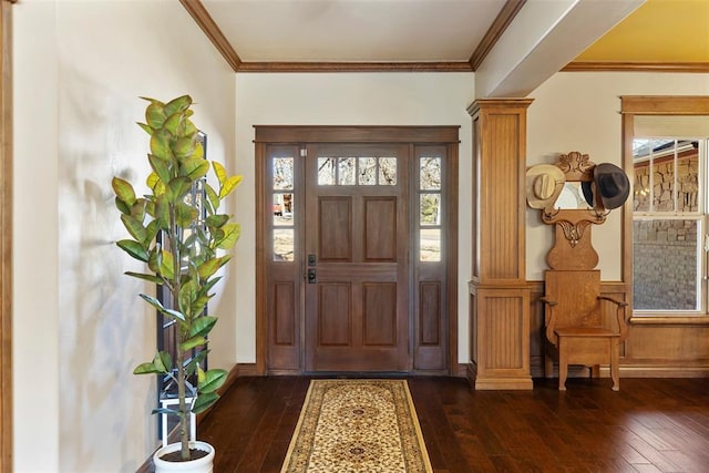 foyer entrance featuring ornate columns, dark wood-type flooring, and crown molding