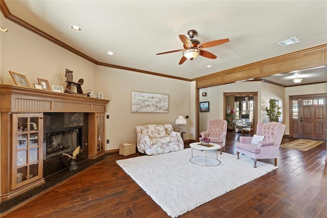 living room with crown molding, visible vents, dark wood finished floors, and a fireplace