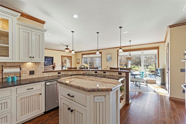 kitchen with plenty of natural light, dark wood finished floors, dishwasher, crown molding, and a sink