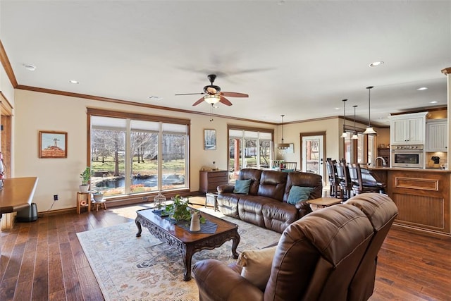 living area featuring ornamental molding, plenty of natural light, and dark wood finished floors