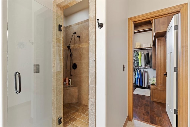 bathroom with a shower stall and wood finished floors