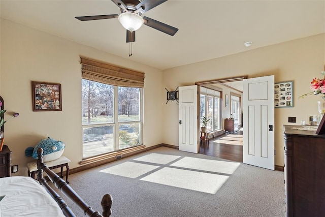 bedroom featuring baseboards, a ceiling fan, and light colored carpet