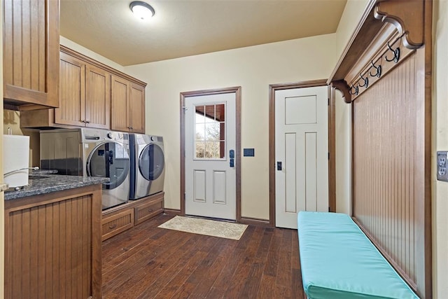 clothes washing area featuring baseboards, dark wood-type flooring, cabinet space, and washer and dryer