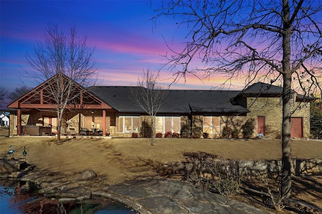 back of house at dusk with a patio