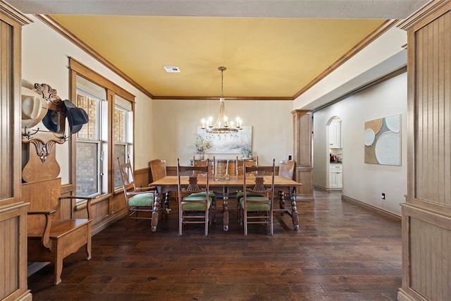 4600 Clipper Xing, Edmond, OK 73013 - dining space with dark wood-type flooring, a chandelier, a wainscoted wall, ornamental molding, and arched walkways