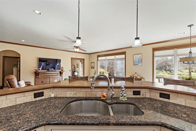 4600 Clipper Xing, Edmond, OK 73013 - kitchen with a sink, open floor plan, plenty of natural light, hanging light fixtures, and crown molding