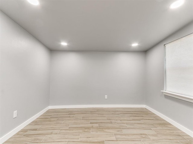 spare room featuring baseboards, recessed lighting, and wood tiled floor