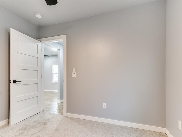 spare room with light colored carpet and baseboards