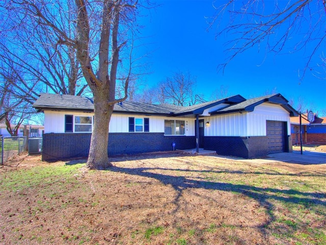 ranch-style home with brick siding, an attached garage, fence, and a front yard