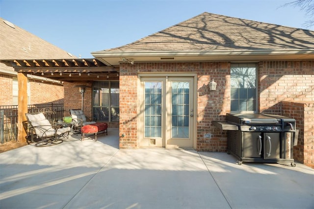 view of patio featuring a grill and fence