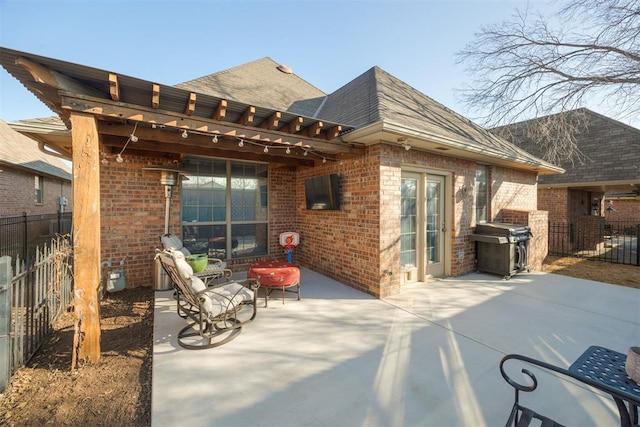 view of patio featuring grilling area, a pergola, and fence