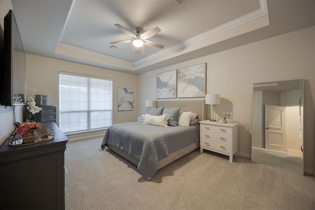 bedroom with visible vents, light colored carpet, a tray ceiling, and ornamental molding