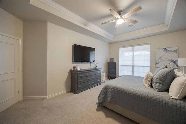 bedroom with a tray ceiling, light colored carpet, visible vents, and ornamental molding