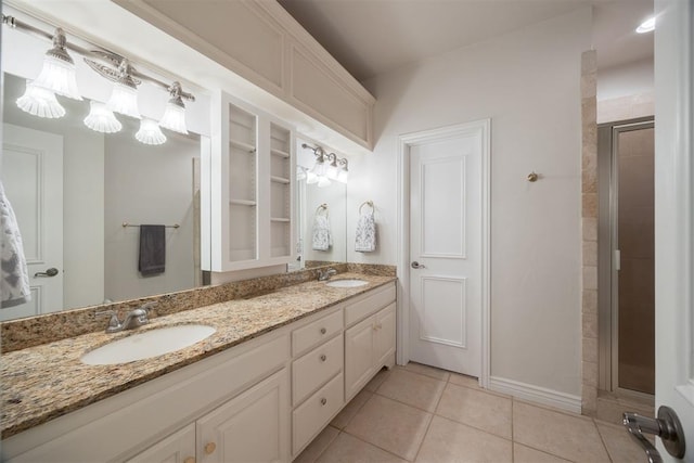 bathroom with tile patterned floors, double vanity, a shower stall, and a sink