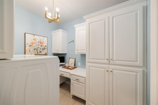 home office featuring light tile patterned floors, built in desk, washer / clothes dryer, and an inviting chandelier