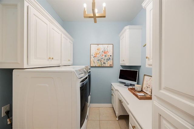 clothes washing area featuring washing machine and clothes dryer, baseboards, light tile patterned floors, an inviting chandelier, and cabinet space