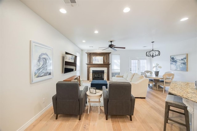 living room with recessed lighting, visible vents, light wood-style flooring, and a fireplace