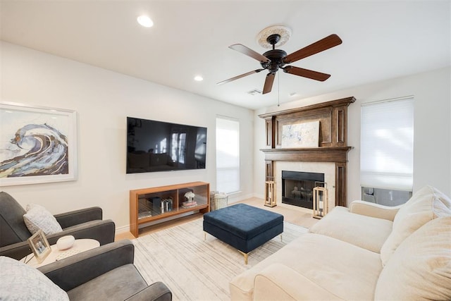 living area featuring baseboards, visible vents, recessed lighting, a fireplace with raised hearth, and ceiling fan