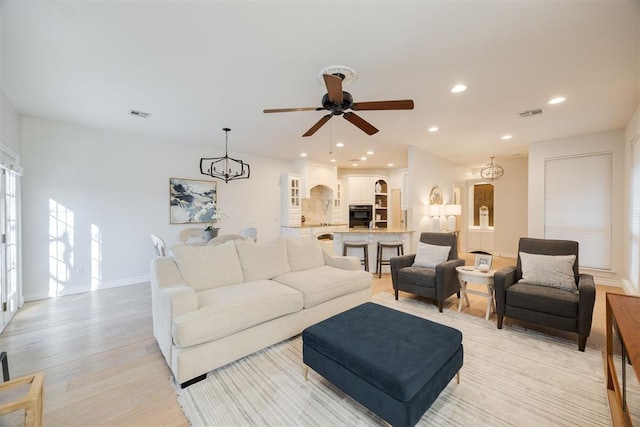 living area featuring visible vents, recessed lighting, baseboards, and light wood-style floors