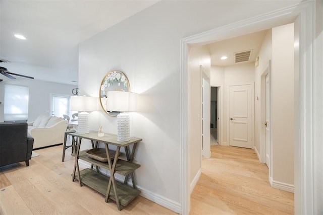 hall with light wood-type flooring, visible vents, baseboards, and recessed lighting