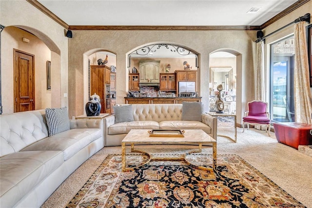 living area with ornamental molding, a textured wall, arched walkways, and light carpet