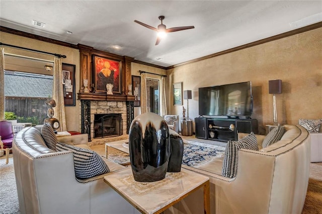 carpeted living area featuring visible vents, a ceiling fan, a stone fireplace, and crown molding