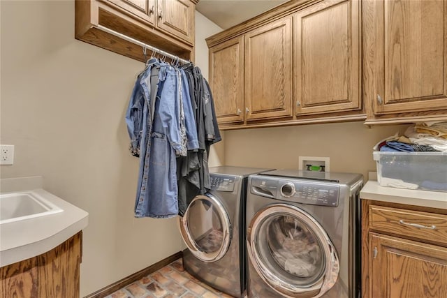 clothes washing area featuring cabinet space, brick floor, baseboards, and separate washer and dryer