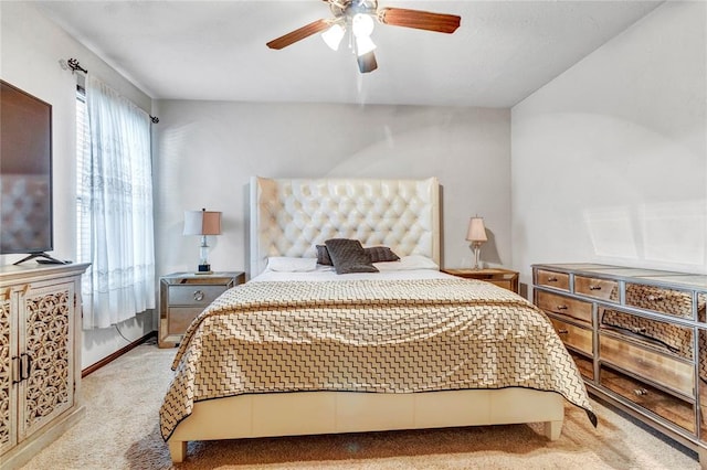 bedroom featuring baseboards, light colored carpet, and a ceiling fan