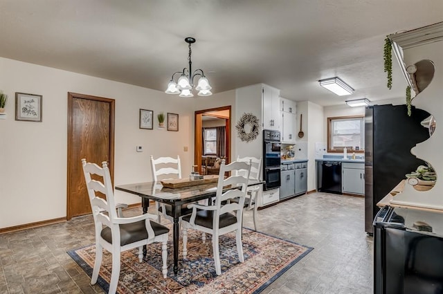 dining space with baseboards and a notable chandelier