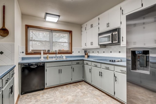 kitchen with white cabinets, decorative backsplash, gray cabinets, black appliances, and a sink