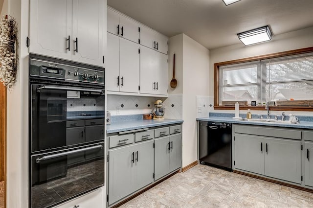 kitchen featuring black appliances, tasteful backsplash, and a sink