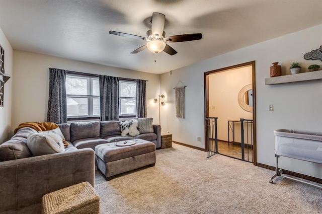 living room with a ceiling fan, light carpet, and baseboards