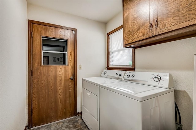 laundry area with washer and dryer, stone finish floor, and cabinet space