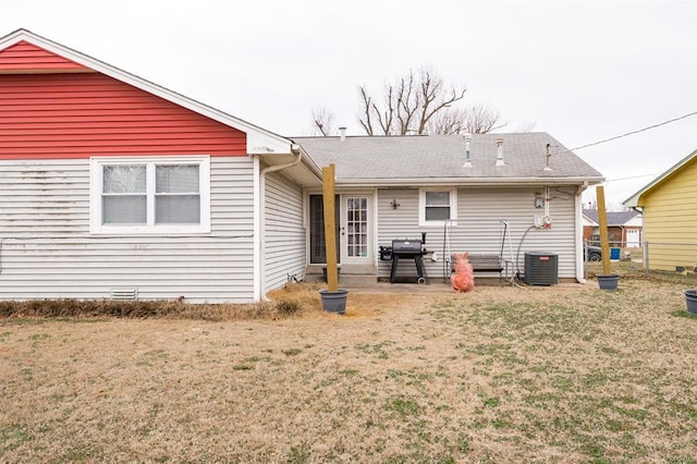 rear view of property with a yard, central AC unit, and fence