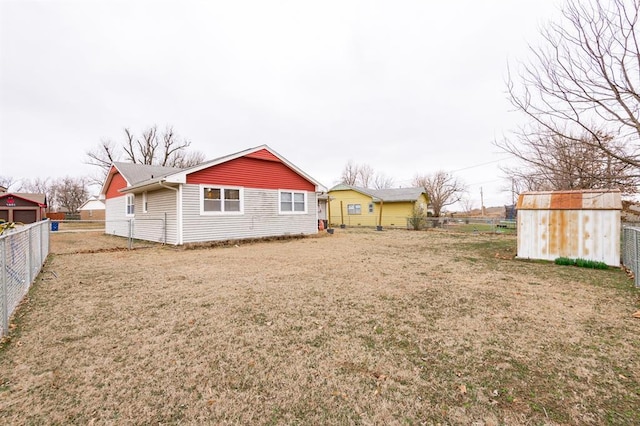 rear view of house with a yard and fence