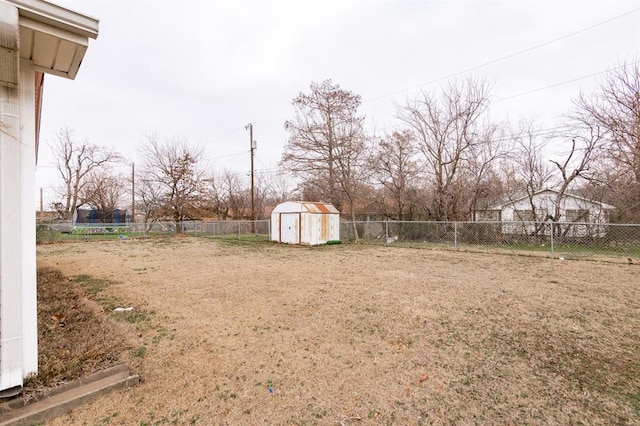 view of yard with a fenced backyard, an outdoor structure, and a storage shed