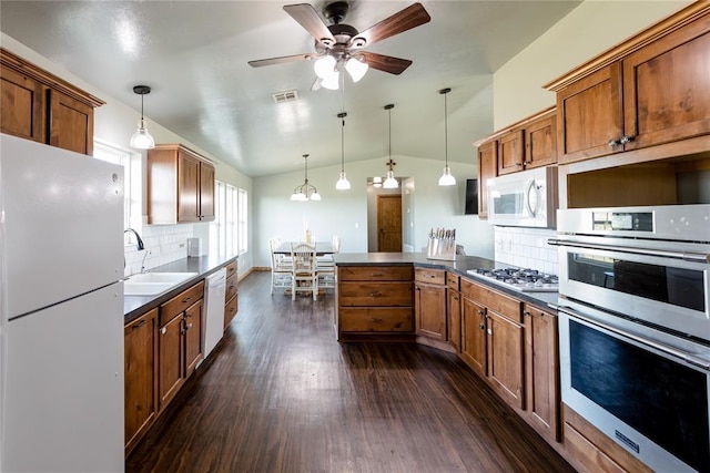 kitchen with visible vents, brown cabinetry, dark wood-style floors, appliances with stainless steel finishes, and a sink