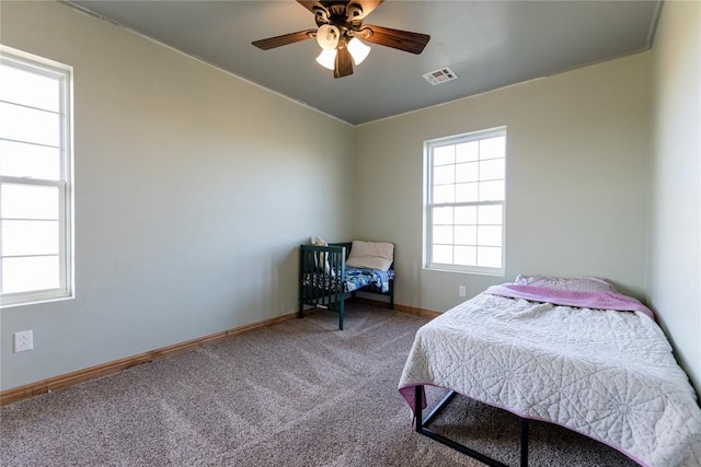 bedroom featuring carpet floors, visible vents, baseboards, and a ceiling fan