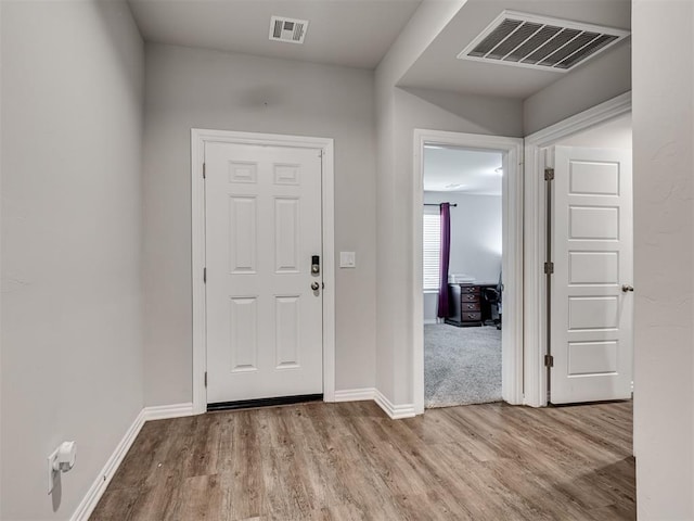 entrance foyer featuring wood finished floors, visible vents, and baseboards